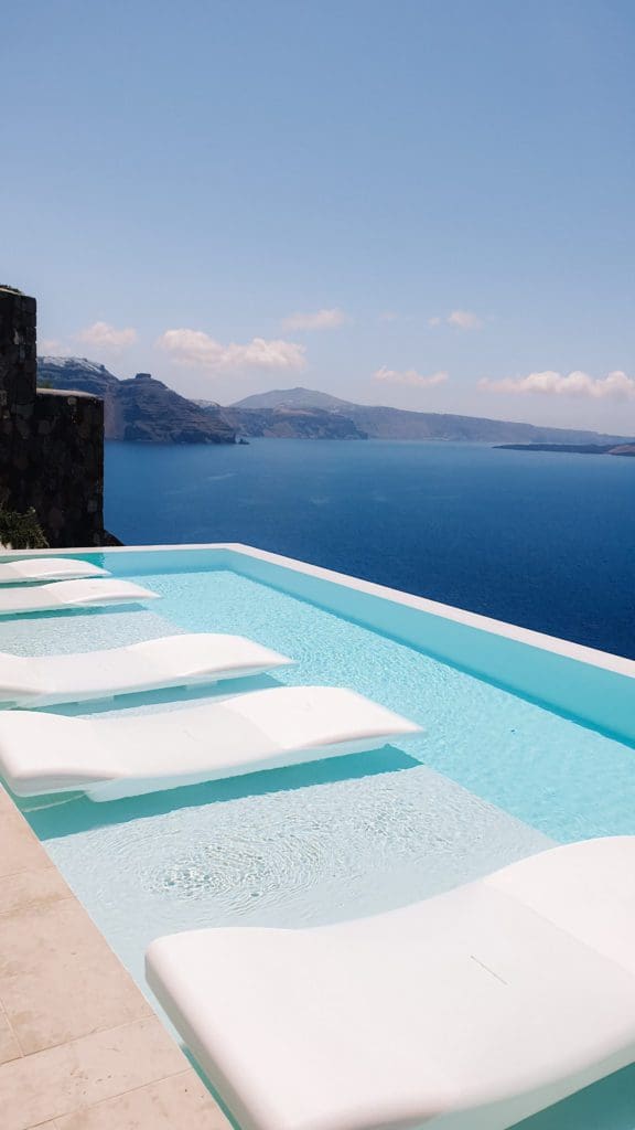 Infinity Pool in Canaves Oia Suites with sunbeds in the water.