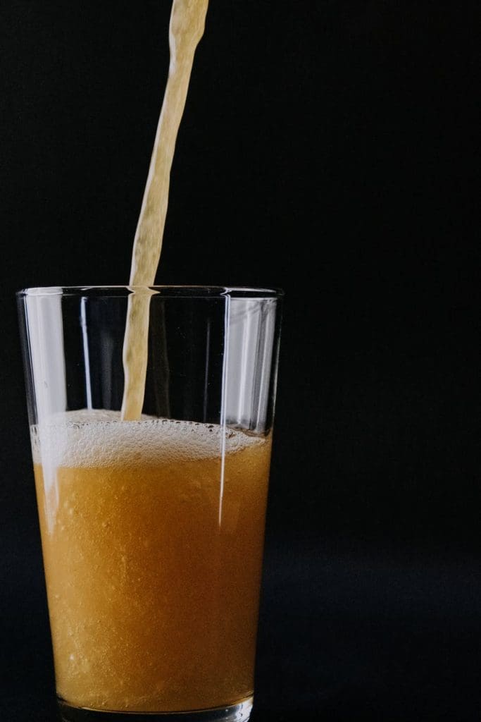 pouring yellow liquid on clear glass