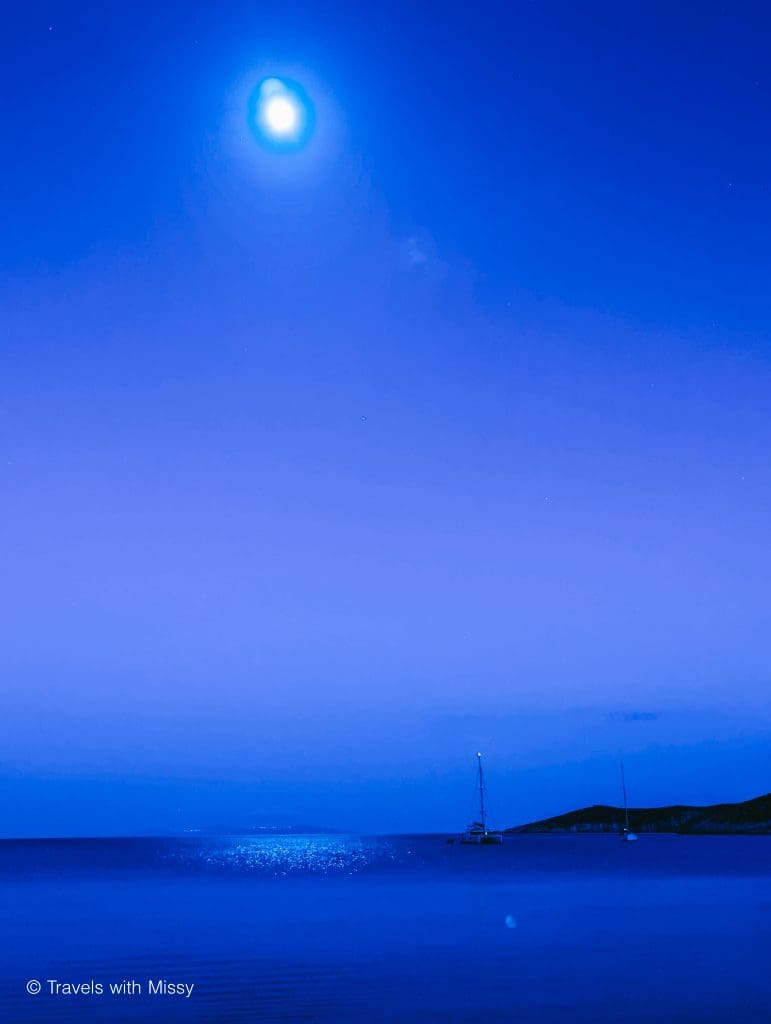The moon shines brightly on a yacht in the bay of Platis Gialos in Sifnos.