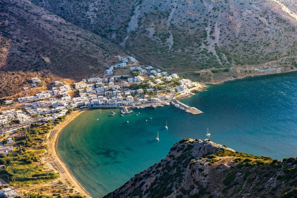 View over the bay of Kamares in Sifnos - tall mountains soar over the tiny beach town.