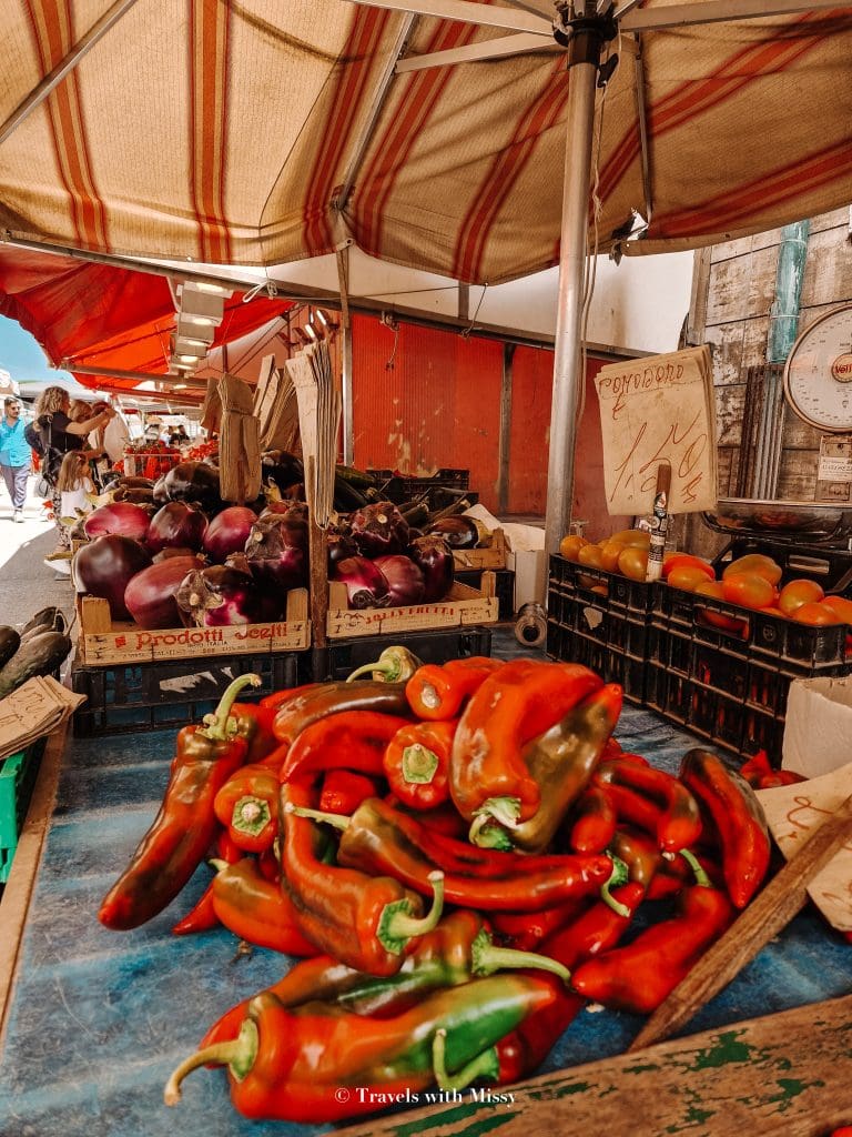 Large red peppers displayed in Ortigia Street Market.