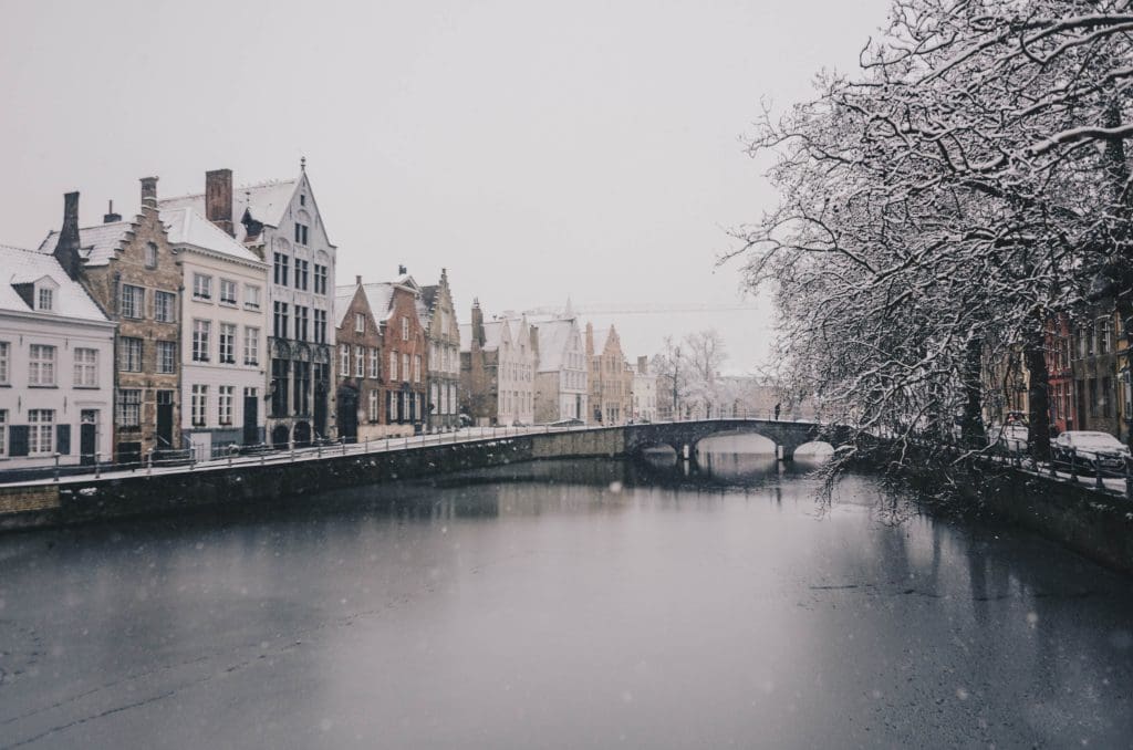 The pretty snow covered bridges of Bruges. One of the Best European Cities for Christmas.