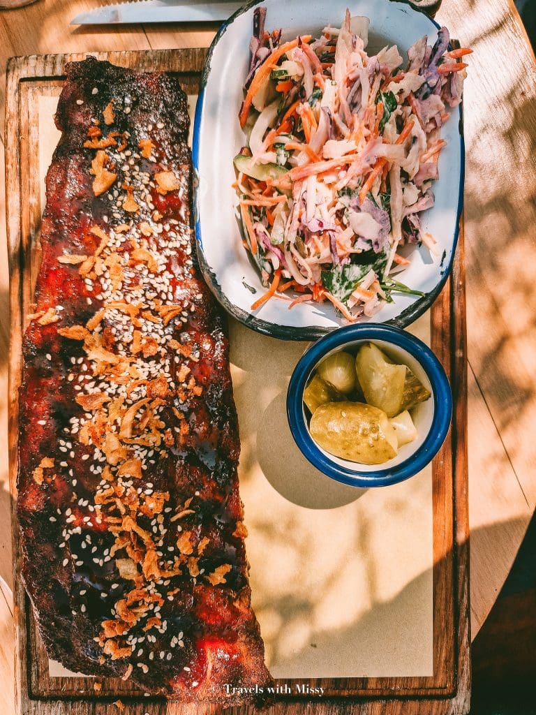 A rack of ribs acompanied by a side of coleslaw pickles in Black Smoke Antwerp.