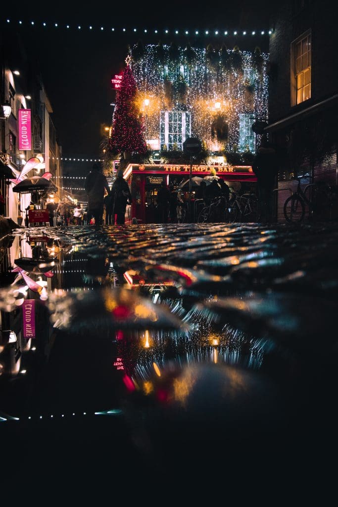 Cobblestones are illuminated in Temple Bar, Dublin from the Christmas lights hanging on the side the The Temple Bar Pub. 